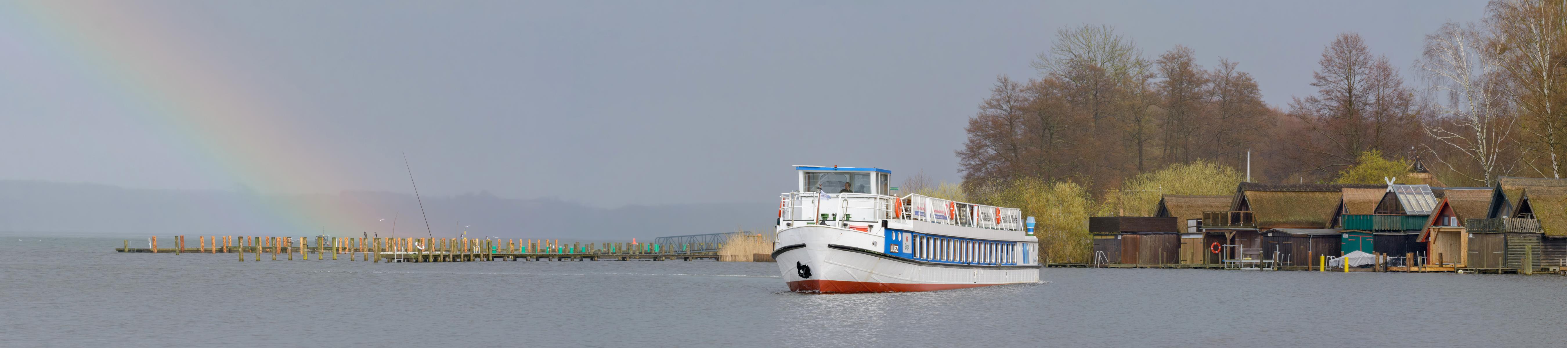 Aussicht auf den Außensee Schwerin mit dem Fahrgastschiff im Regen, im Hintergrund ein Regenbogen als Panoramabild